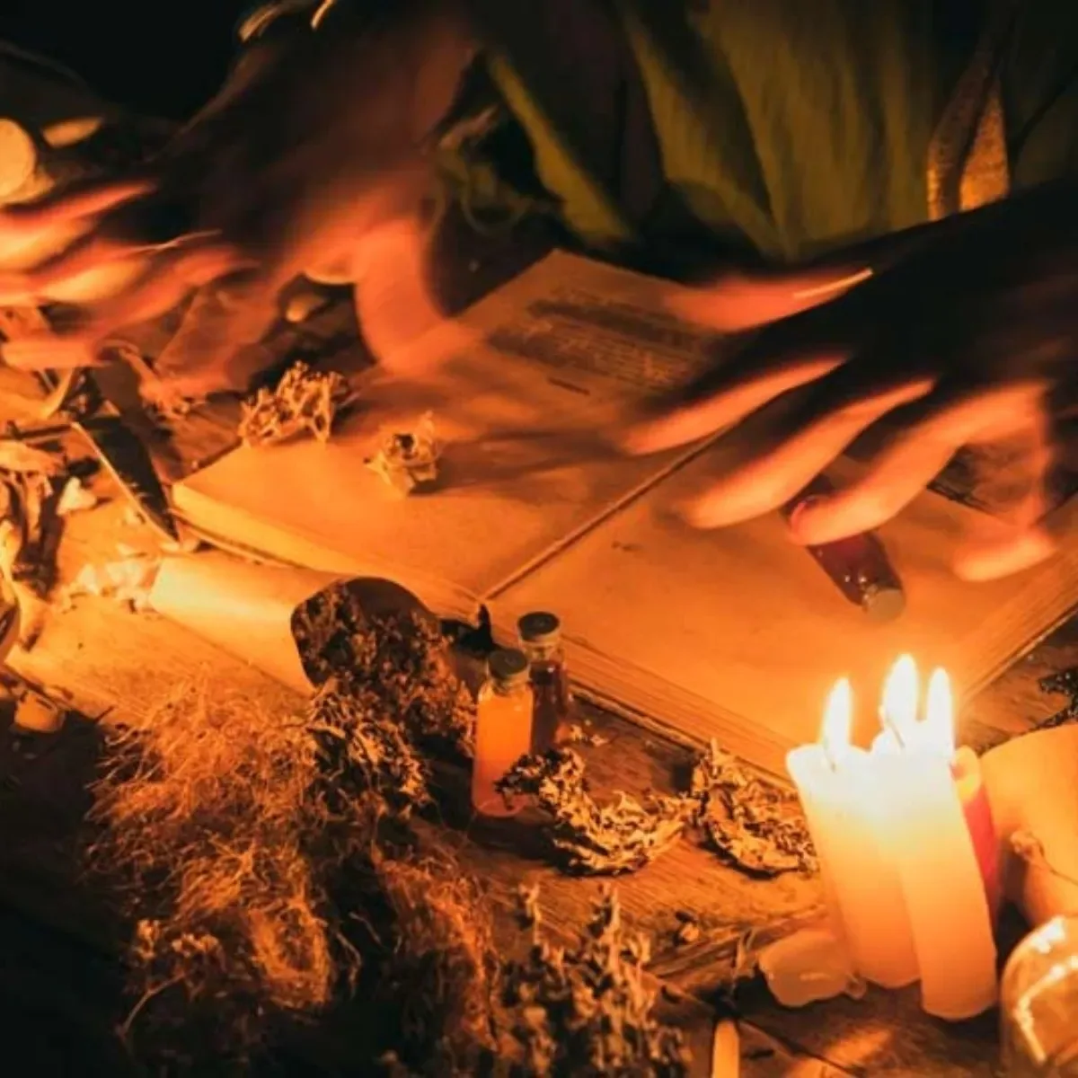 Manos escribiendo a la luz de las velas