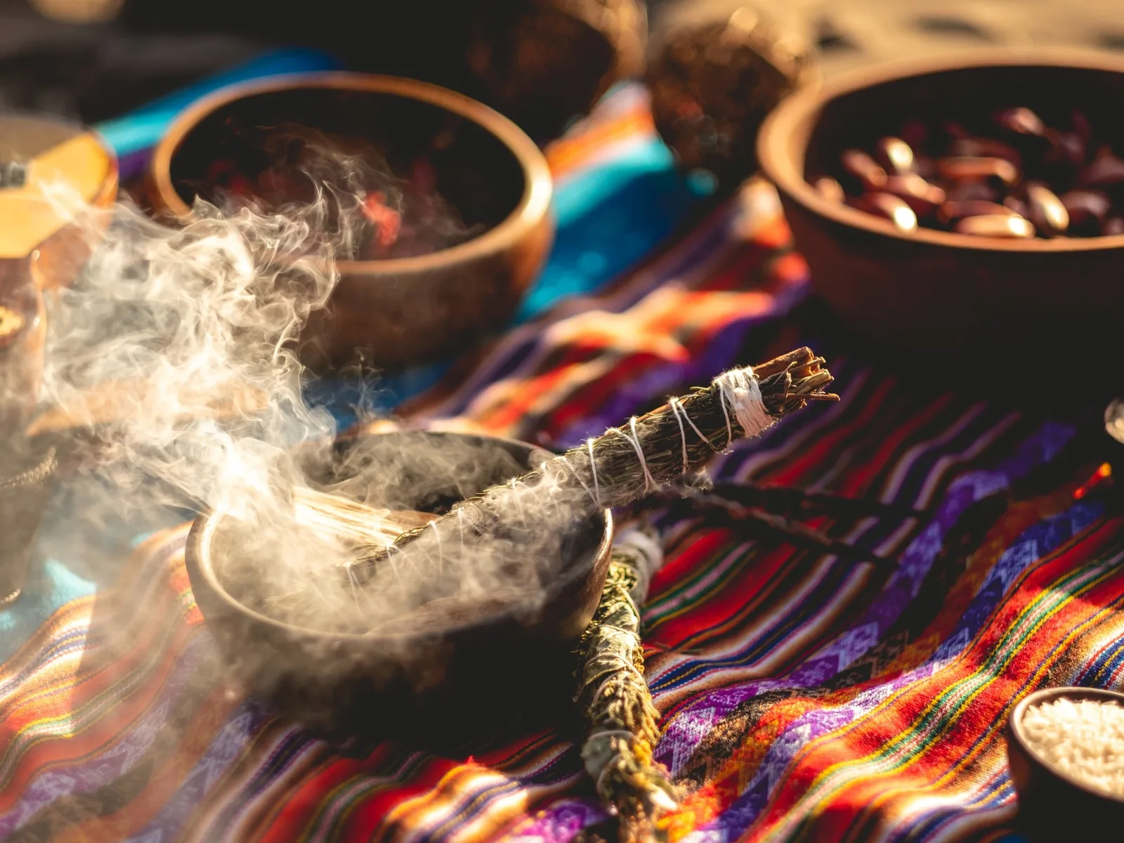 Humo de hierbas sobre tejido tradicional con cuencos